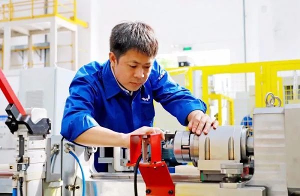 △鄭志明正在對襯套自動壓裝設(shè)備進行檢測調(diào)試。