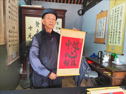 越南首都河內(nèi)文廟內(nèi)，阮明珠展示“中越心相近”書法作品。