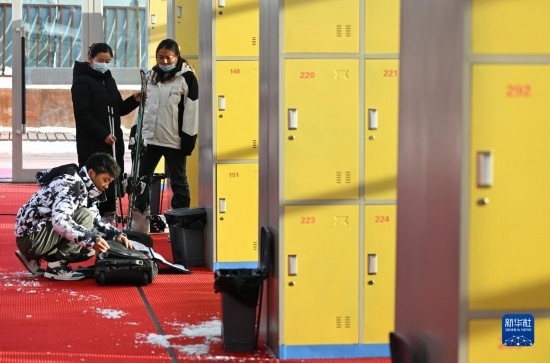 12月21日，游客在滑雪服務(wù)大廳整理滑雪裝備。