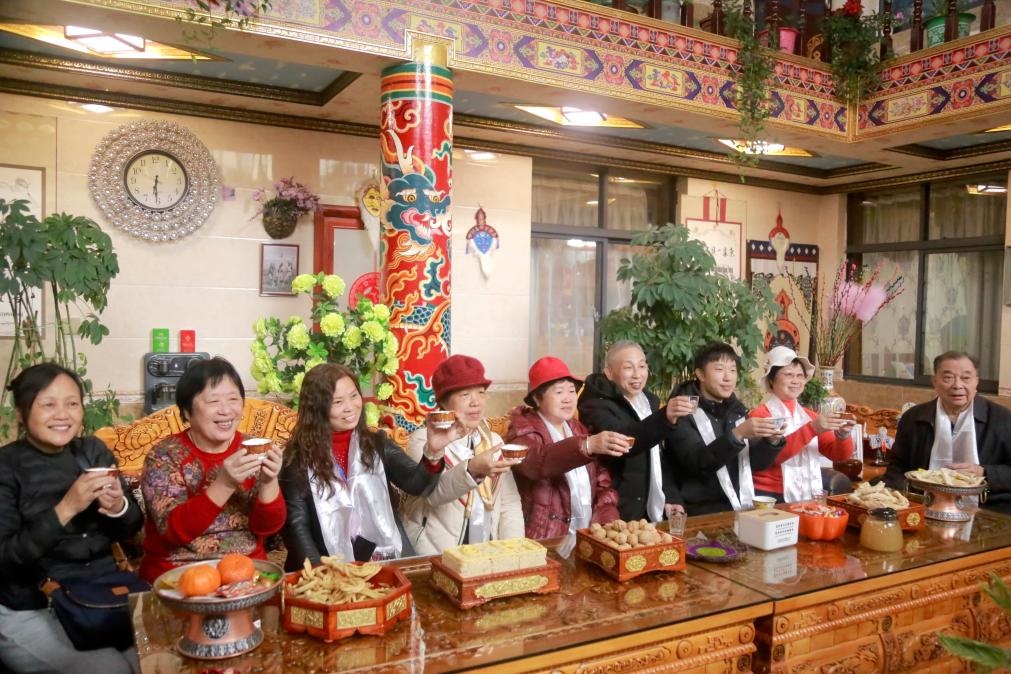 游客們?nèi)胱∶袼藓螅e杯共飲酥油茶。新華社記者 邱星翔 攝