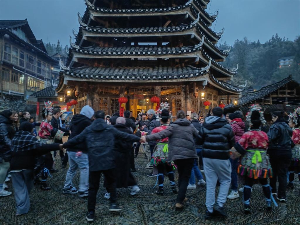 法國青年與當(dāng)?shù)卮迕駹渴痔?。新華社記者 羅羽 攝