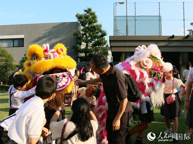 孩子們好奇地圍觀(guān)舞獅。人民網(wǎng) 許可攝