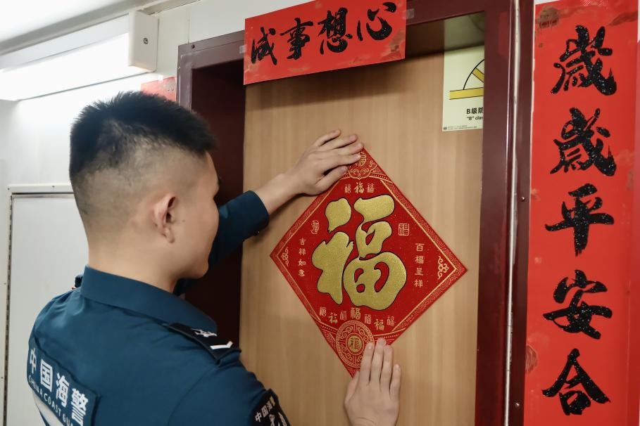 1月27日，在中國(guó)海警海鷗艦上，執(zhí)法員貼春聯(lián)福字慶祝農(nóng)歷春節(jié)。